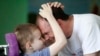 Volunteer Brendan Galvin from Ireland plays with a child at an orphanage near the village of Vesnovo. Nurses, doctors, and physiotherapists are among the foreign volunteers at the institution.