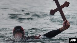 A Romanian diver shows a wooden cross he retrieved from the Black Sea during an Epiphany religious service in Constanta.