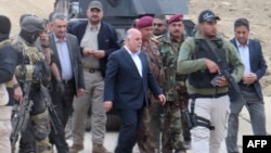 Iraqi Prime Minister Haider al-Abadi (center) visits Ramadi on December 29 after the city had been retaken from Islamic State extremists. 