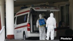 Armenia -- Workers disinfect an ambulance outside Surp Girgor Lusavorich hospital in Yerevan, April 8, 2020.