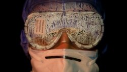 Zaštitne naočale na licu vojnikinje u Nepalu nakon sahrane preminulih od COVID-a 19