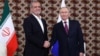 Russian President Vladimir Putin (right) shakes hands with Iranian President Masud Pezeshkian in Ashgabat on October 11.