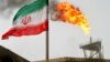 A gas flare on an oil production platform in the Soroush oil fields is seen alongside an Iranian flag in the Gulf 