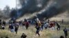 Palestinian protesters run for cover during clashes with Israeli troops as Palestinians call for a "day of rage" in response to U.S. President's recognition of Jerusalem as Israel's capital.