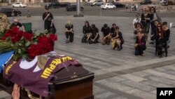 Ljudi odaju počast kod kovčega Darije Filipieve, borbenog lekara ukrajinske vojske koja je ubijena u oblasti Donjecka, tokom njene sahrane na Trgu nezavisnosti u Kijevu 12. avgusta.