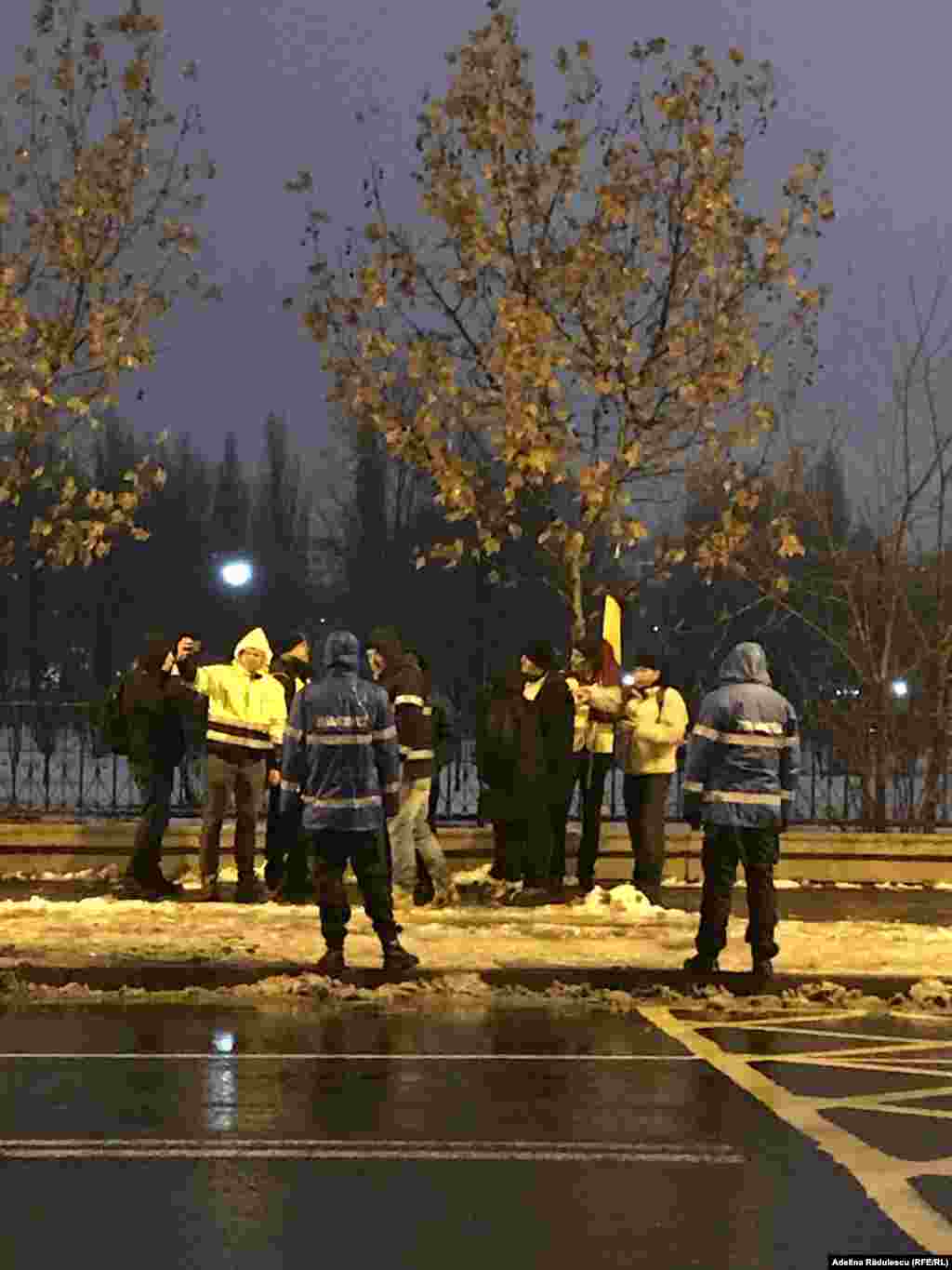 Protestatari scandînd lozinci anti-PSD păziți de jandarmi.