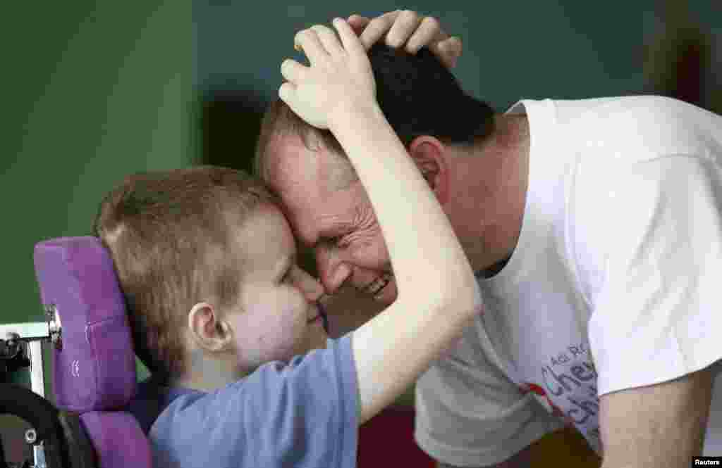 Volunteer Brendan Galvin from Ireland plays with a child at an orphanage near the village of Vesnovo. Nurses, doctors, and physiotherapists are among the foreign volunteers at the institution.