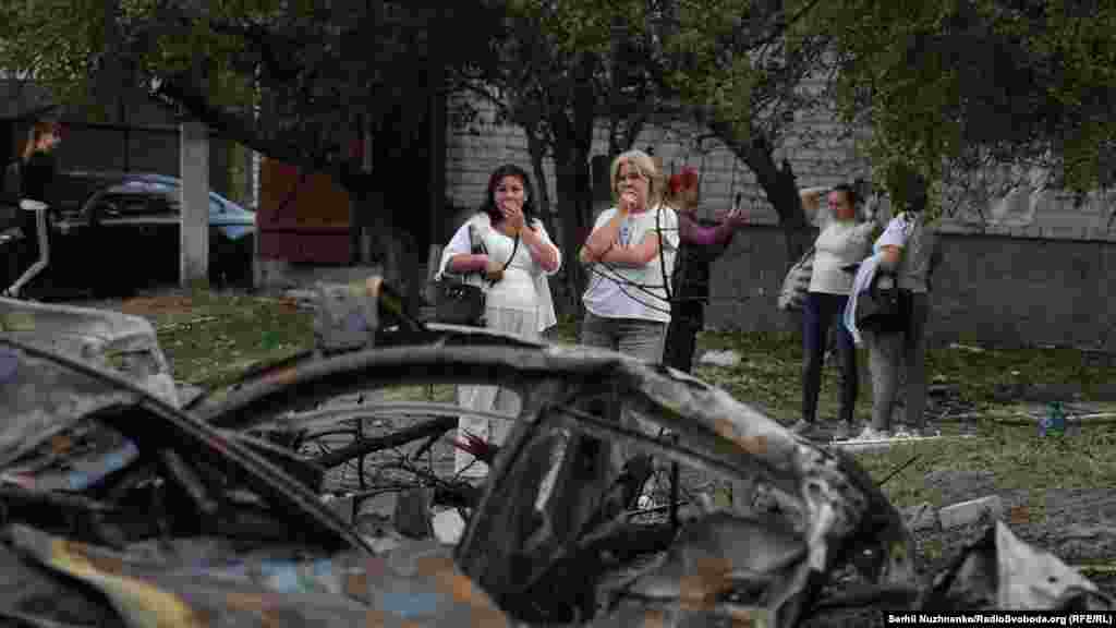 Some local residents stare at what had been a familiar part of their neighborhood before the strike.Tkachenko added that cars, private houses, and a car-repair shop were also damaged in the Russian attack on Boryspil.