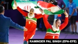 Jafarikoochi Saeideh (right) and Karami Khatouban Fatemeh of Iran celebrate after defeating India during the women's kabaddi final at the 18th Asian Games in Jakarta on August 24.