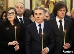 Бидзина Иванишвили с супругой Екатериной Хведелидзе и премьером Ираклием Кобахидзе (справа) на похоронах Католикоса-Патриарха всея Грузии Илии Второго