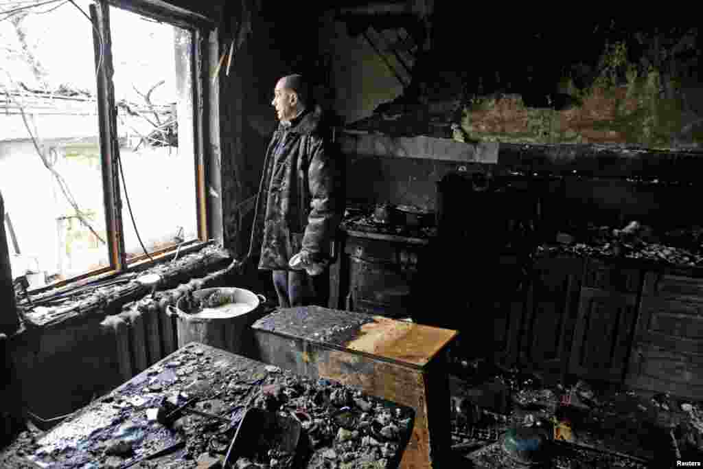 A local resident looks out of a window in his house, which was damaged by shelling in the rebel-held city of Donetsk. (Reuters/Alexander Ermochenko)