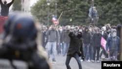 Youths clash with riot police during incidents at the end of a protest march against France's legalization of same-sex marriage.