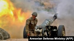 Войник от армията за защита на Нагорни Карабах стреля с артилерийско оръдие срещу азербайджанските позиции