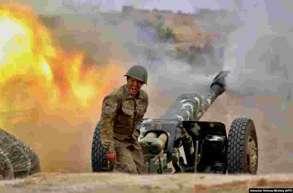 An ethnic Armenian soldier in the separatist Karabakh forces fires an artillery piece toward Azerbaijani positions during fighting over the breakaway Nagorno-Karabakh region on September 28. ( AFP/Armenian Defense Ministry)