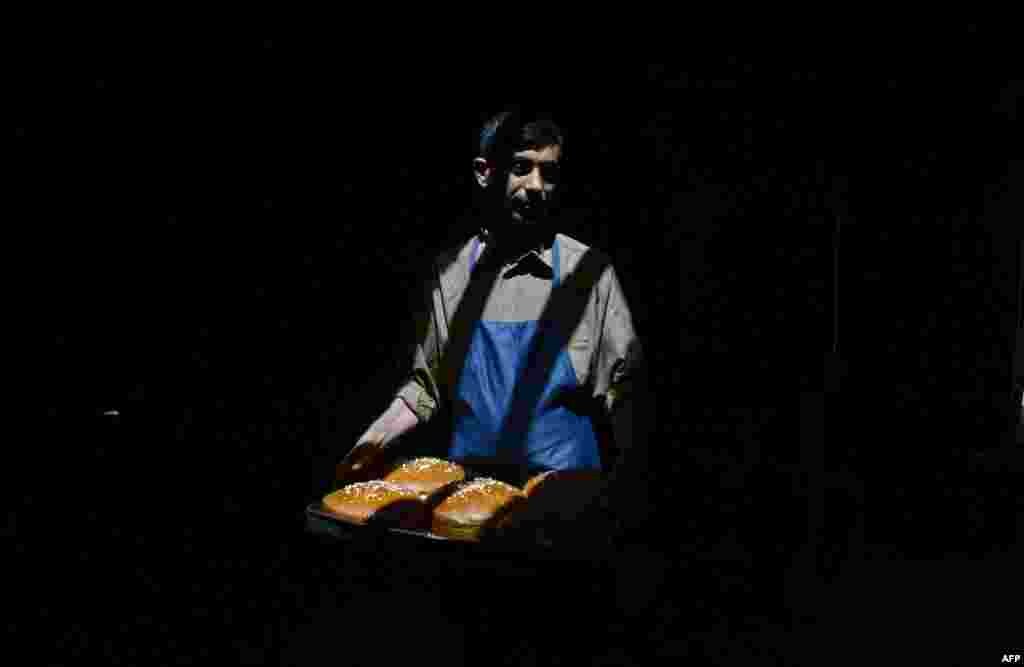 An Afghan laborer carries trays at a traditional sweet factory in Mazar-e Sharif. (AFP/Farshad Usyan)
