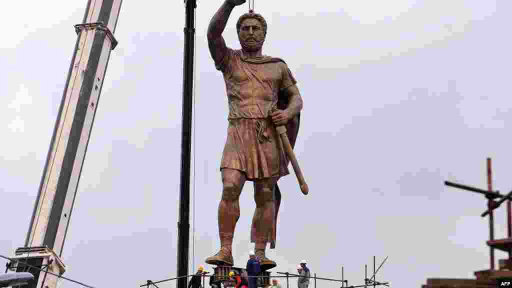 A crane lifts a 13-meter-high bronze statue of Philip II of Macedon, the father of Alexander the Great, onto a 15-meter-high pedestal in central Skopje. 