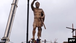 A crane lifts a 13-meter-high bronze statue of Philip II of Macedonia, officially named "The Warrior," onto its 18-meter-high pedestal in central Skopje on May 22.