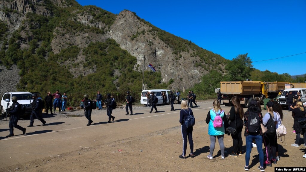 Pjesëtarë të Policisë së Kosovës duke ecur nëpër rrugën e bllokuar nga serbët lokalë, në Jarinjë. (26 shtator)