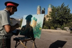 A policeman paints Bukhara’s Chor Minor in 2010.