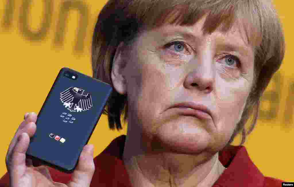 German Chancellor Angela Merkel holds a BlackBerry Z10 smartphone featuring high-security Secusite software used for governmental communication during her opening tour at the CeBit computer fair in Hanover. The biggest fair of its kind runs until March 9. (Reuters/Fabrizio Bensch)