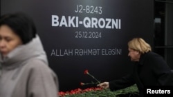 Oamenii depun flori pentru a comemora victimele prăbușirii unui avion de pasageri Embraer al Azerbaijan Airlines lângă orașul kazah Aktau, la un memorial instalat în fața aeroportului din Baku, Azerbaidjan, 26 decembrie 2024.