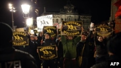 Demonstranți cu inscripții „Refugiații sînt bineveniți”, la o manifestație sub titulatura „Dresda liberă de naziștiˆ, împotriva mișcării Pegida 