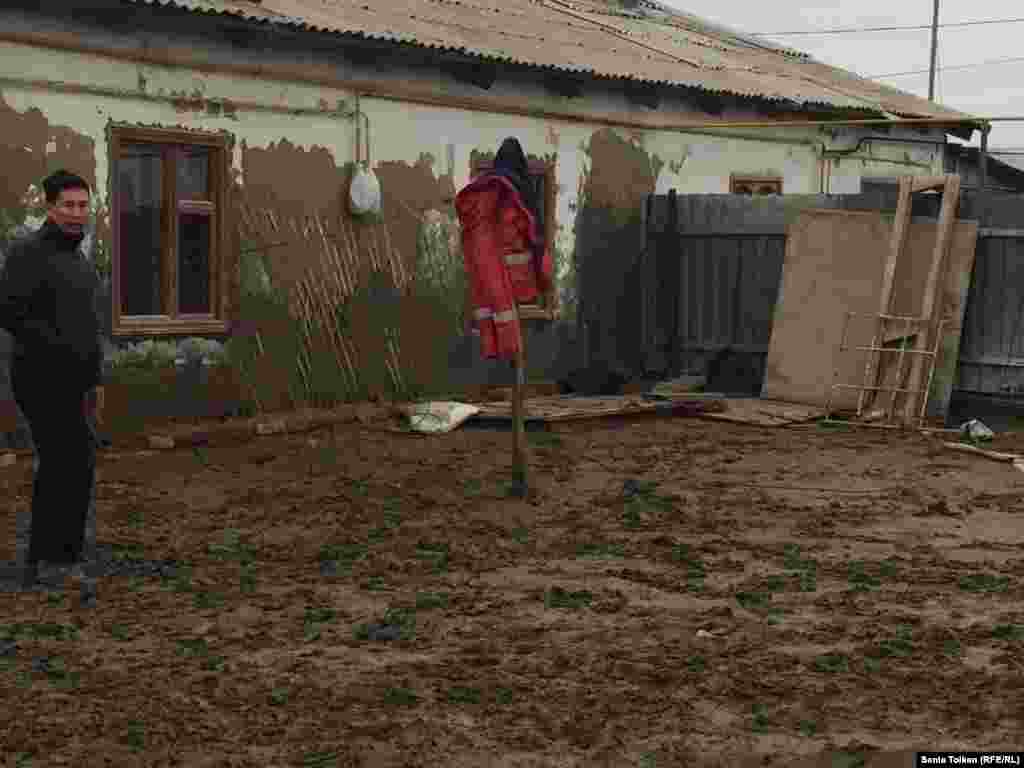 Житель Атырау Адилет Жолдыгулов показывает свой дом, к которому подбирается вода.