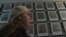 Yevgenia Karatygina in front of portraits of Holocaust victims in a still from the trailer for the documentary "Holocaust -- Wallpaper Paste?"