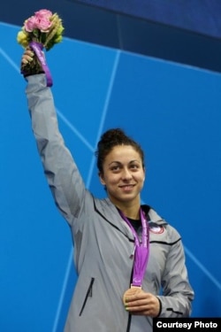 Elizabeth Stone shows off some of her hardware at the Olympic Park Aquatics Center in London.