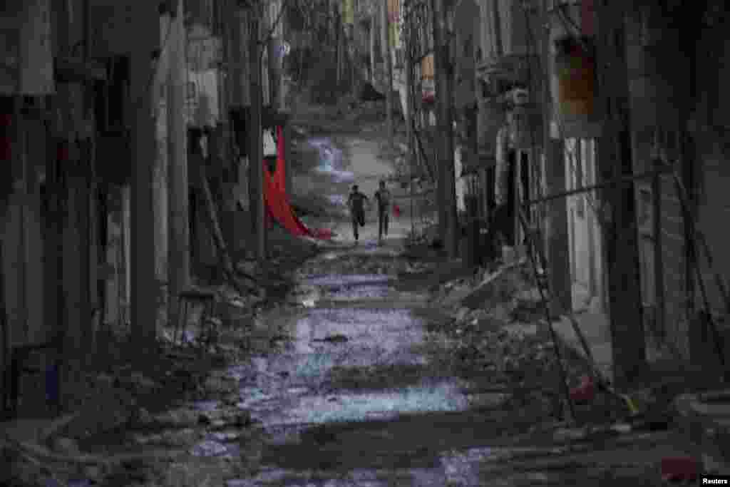 People run down a street in Deir al-Zor amid continued fighting in Syria. (Reuters/Khalil Ashawi)