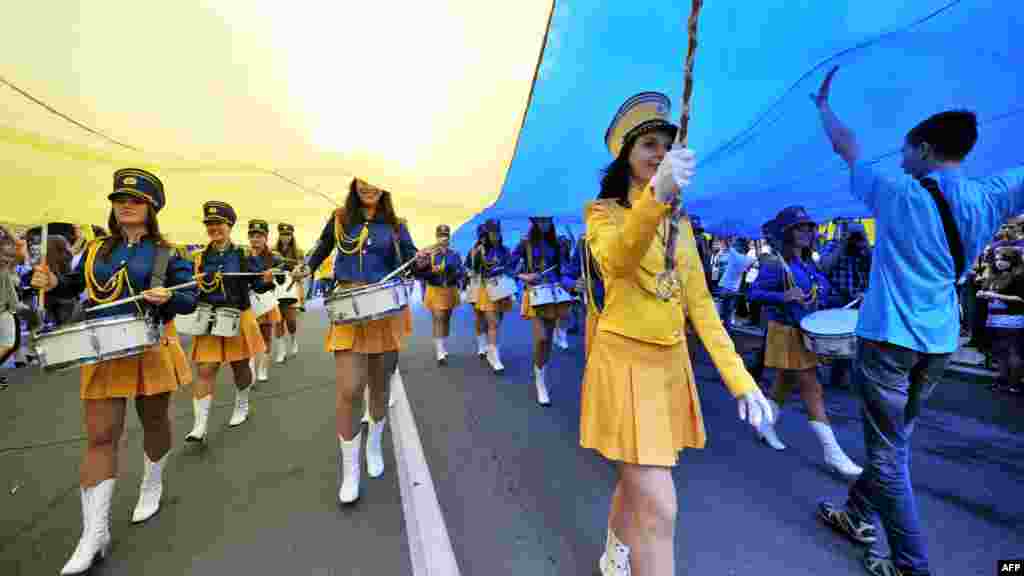 Ukrainian cheerleaders beat drums under a giant Ukrainian flag to mark National Flag Day in Kyiv on August 23.&nbsp; (AFP/Genya Savilov)