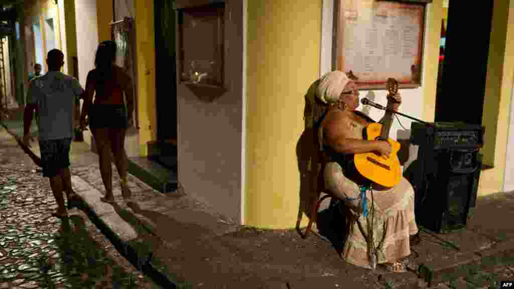 A woman sings while playing guitar in Salvador&#39;s historic center during Dia do Samba (&quot;Samba Day&quot;) on December 2. (AFP Photo/Yasuyoshi Chiba)