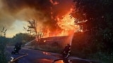 This handout photograph taken and released by Ukrainian State Emergency Service on July 9 shows firefighters extinguishing a fire after a Russian attack in Kyiv region.