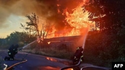Рятувальники гасять пожежу, що виникла внаслідок одного з попередніх російських ударів по Київщині, липень 2025 року