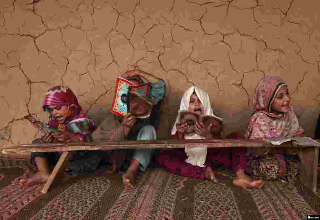 Pakistani girls read books containing short verses from the Koran in a madrasah, or religious school, on the outskirts of Islamabad. (Reuters/Faisal Mahmood)