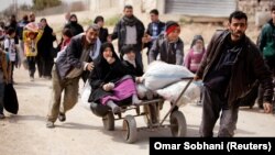 People flee the rebel-held town of Hammuriyeh on March 15.