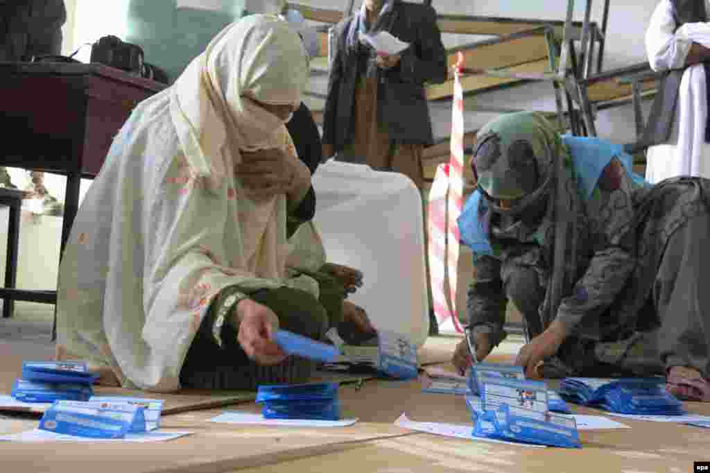 Workers with the Afghan Independent Election Commission count ballots at a polling station for the presidential elections in Kandahar on April 5.