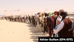 People wait in line to cross the Afghan-Pakistani border at the Chaman border crossing on September 20.