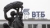 Russia -- Part of a monument to Soviet state founder Vladimir Lenin is seen against a sign for VTB Bank in Stavropol, January 22, 2015