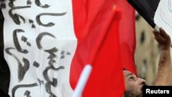 Egypt -- A protester holds an Egyptian flag during a protest in Cairo, 07Feb2011