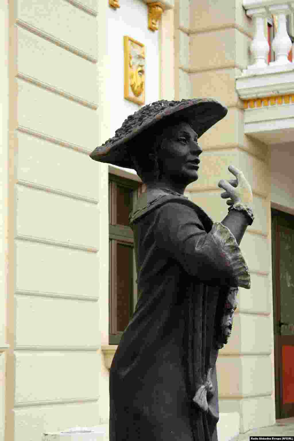 A statue stands by the entrance to a newly built theater, which is a replica of a building demolished in a 1963 earthquake.