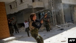 Syrian rebels fire at an army sniper in the Salaheddin district of the northern city of Aleppo on August 13, where fierce fighting continues for Syria's largest city.