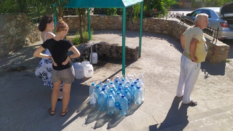 Люди набирают воду из артезианской скважины термальных вод в селе Верхнесадовое | Крымское фото дня