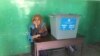 An election commission worker sits next to an empty ballot box in a women's voting center in Kabul on September 28.
