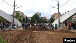 Local ethnic Serbs shovel soil to form a barricade on the main bridge in the ethnically divided Kosovo town of Mitrovica. Earlier this week a barricade on the bridge had been removed in what seemed to be the latest hint of a tentative thaw with their Albanian neighbors. But the bridge was then blocked again a a day later with concrete pots and earth. 