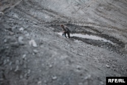 Мужчина собирает уголь на шахтной насыпи