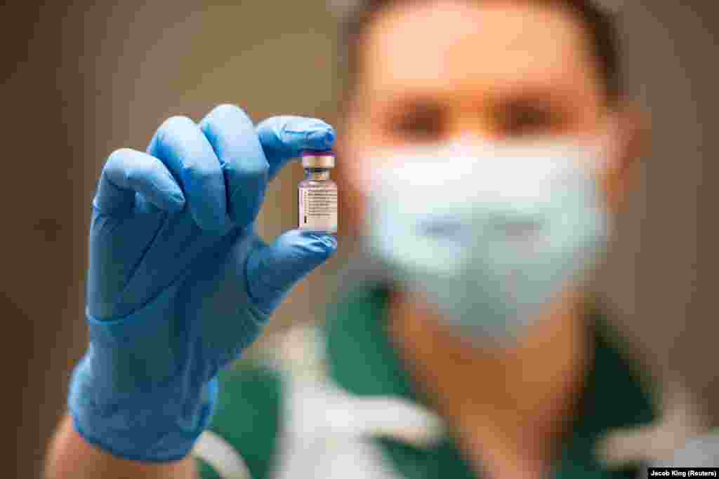 A Prizer-BioNTech koronavírus-vakcina egy fioláját tartja kezében ez a brit ápolónő.
