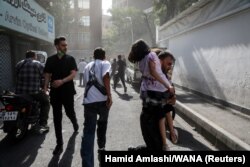 Ljudi trče ulicom usred dima nakon izraelskih napada na Iran, u Teheranu, Iran, 15. juna 2025.