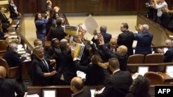 Ченови на арапскиот парламентарен блок држат транспаренти во знак на протест за време на говорот на Пенс. 