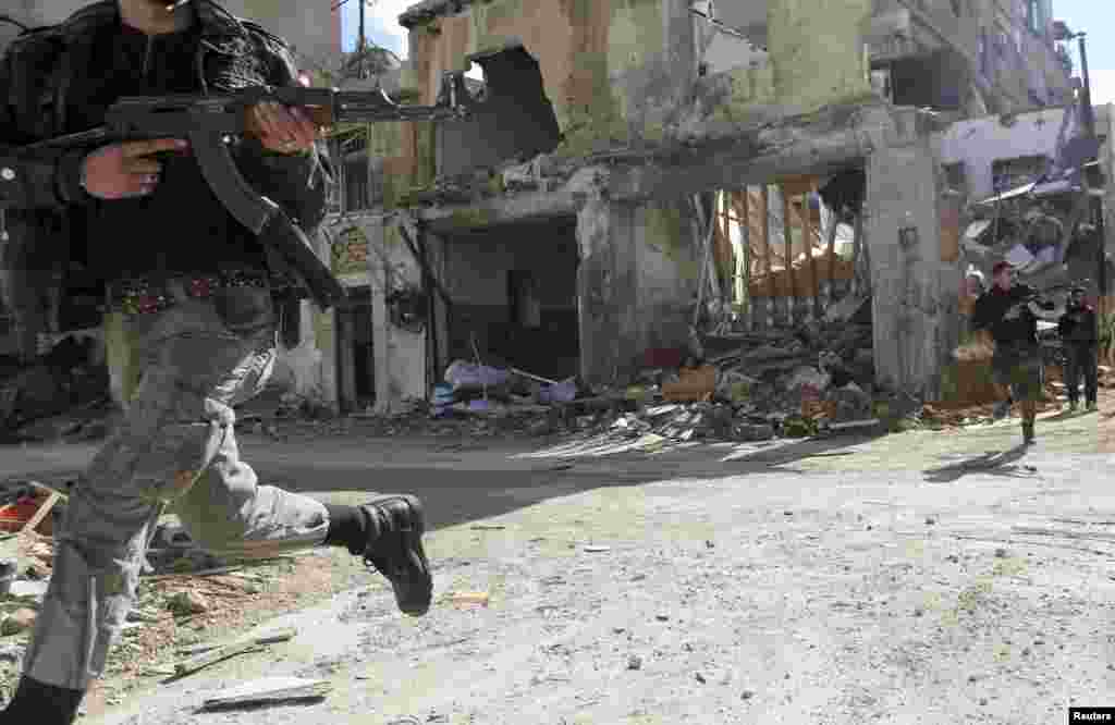 Members of the Fateh al Sham unit of the Free Syrian Army run across a street in the Haresta neighborhood of Damascus. (Reuters/Goran Tomasevic)